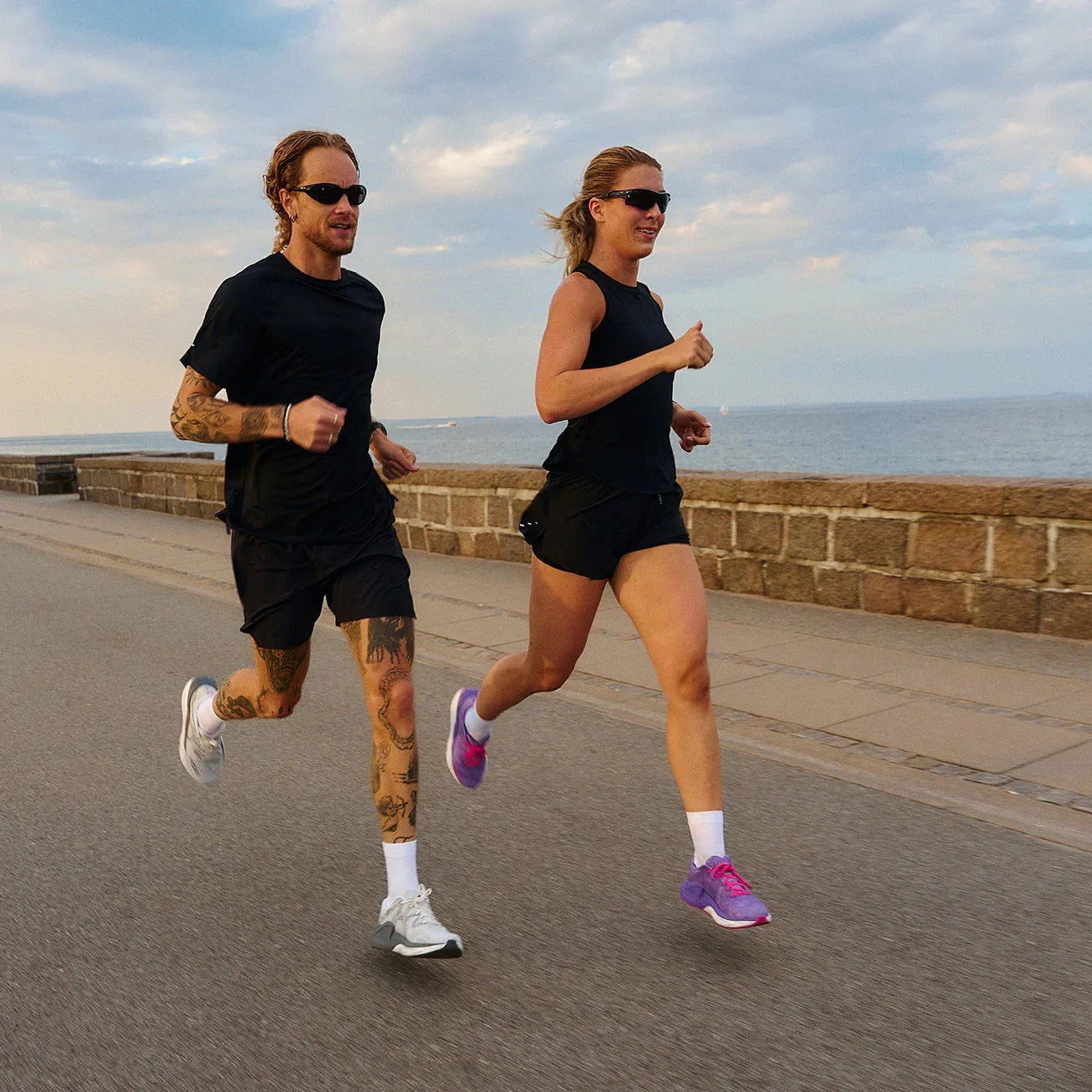 Man running outdoors wearing white and grey minimalist injury-reducing running shoes